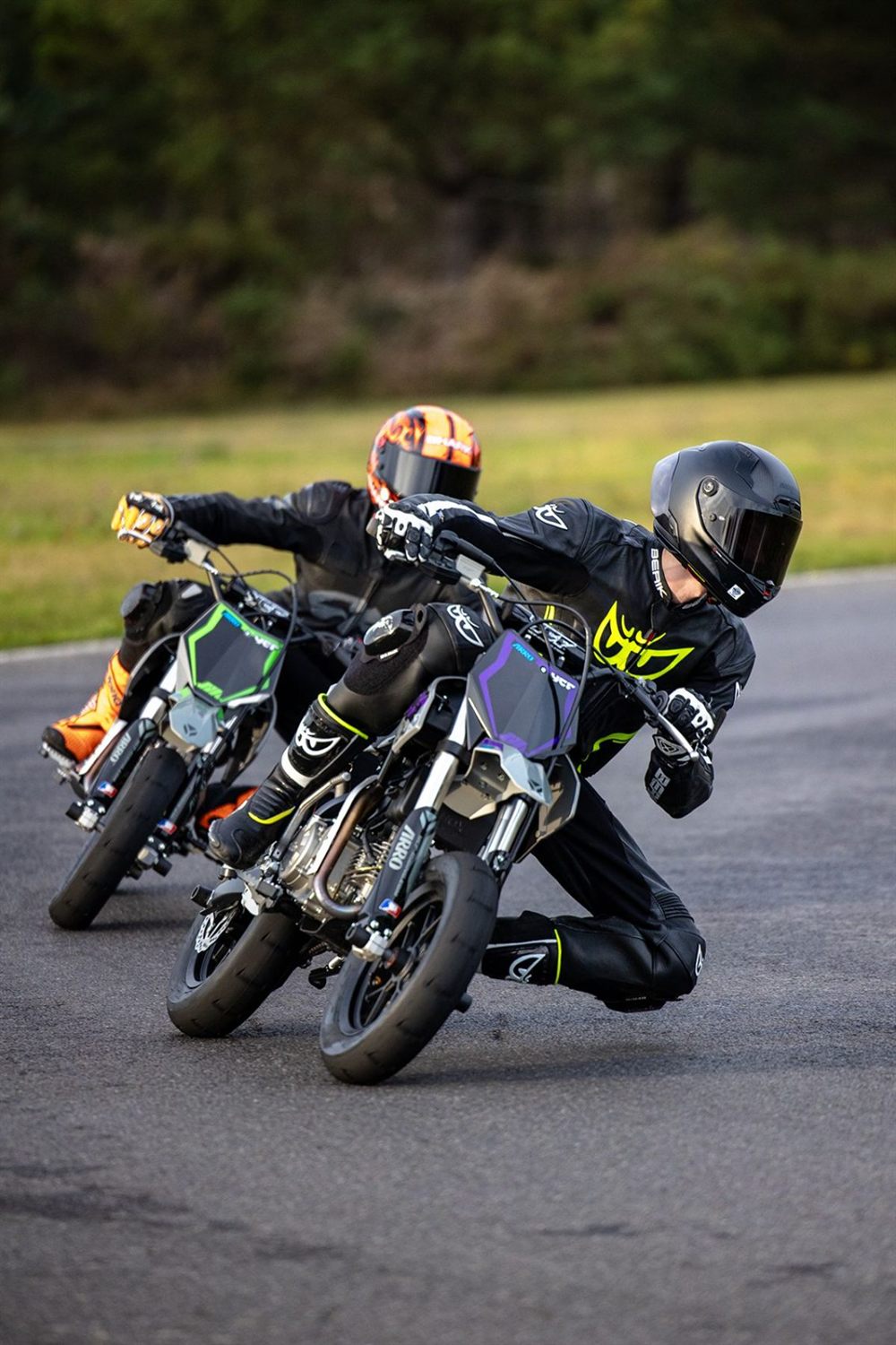 Deux pilotes de supermotard en virage, genou à terre