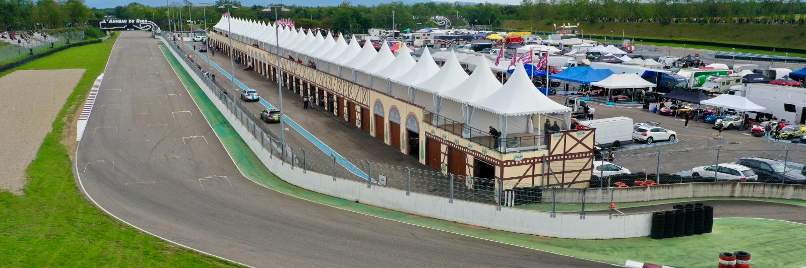 Ligne droite des stands de l’Anneau du Rhin, ses boxes, ses chapiteaux et le paddock en activité