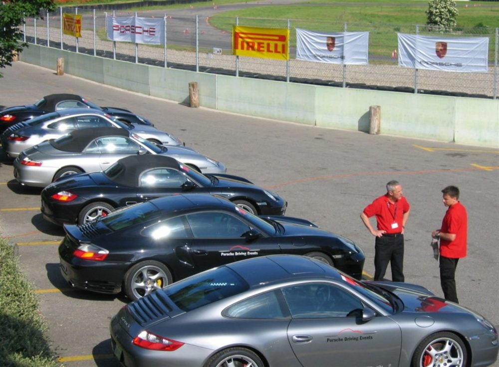 Plateau de Porsche aligné au paddock lors d'une journée organisateur