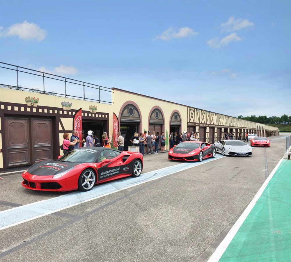 Supercars alignées devant les boxes lors d’une journée de stages