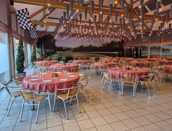 Salle en configuration banquet, tables rondes dressées
