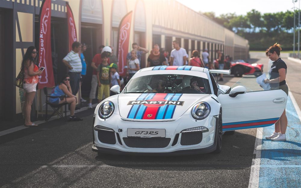 Porsche GT3 RS accueillie devant les stands avant une session