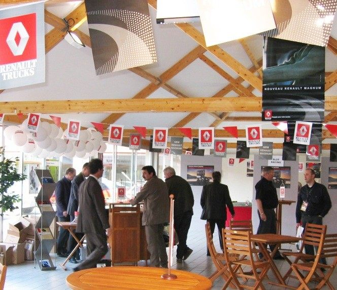 Salle de réception aménagée pour un séminaire constructeur, stands et mange-debout